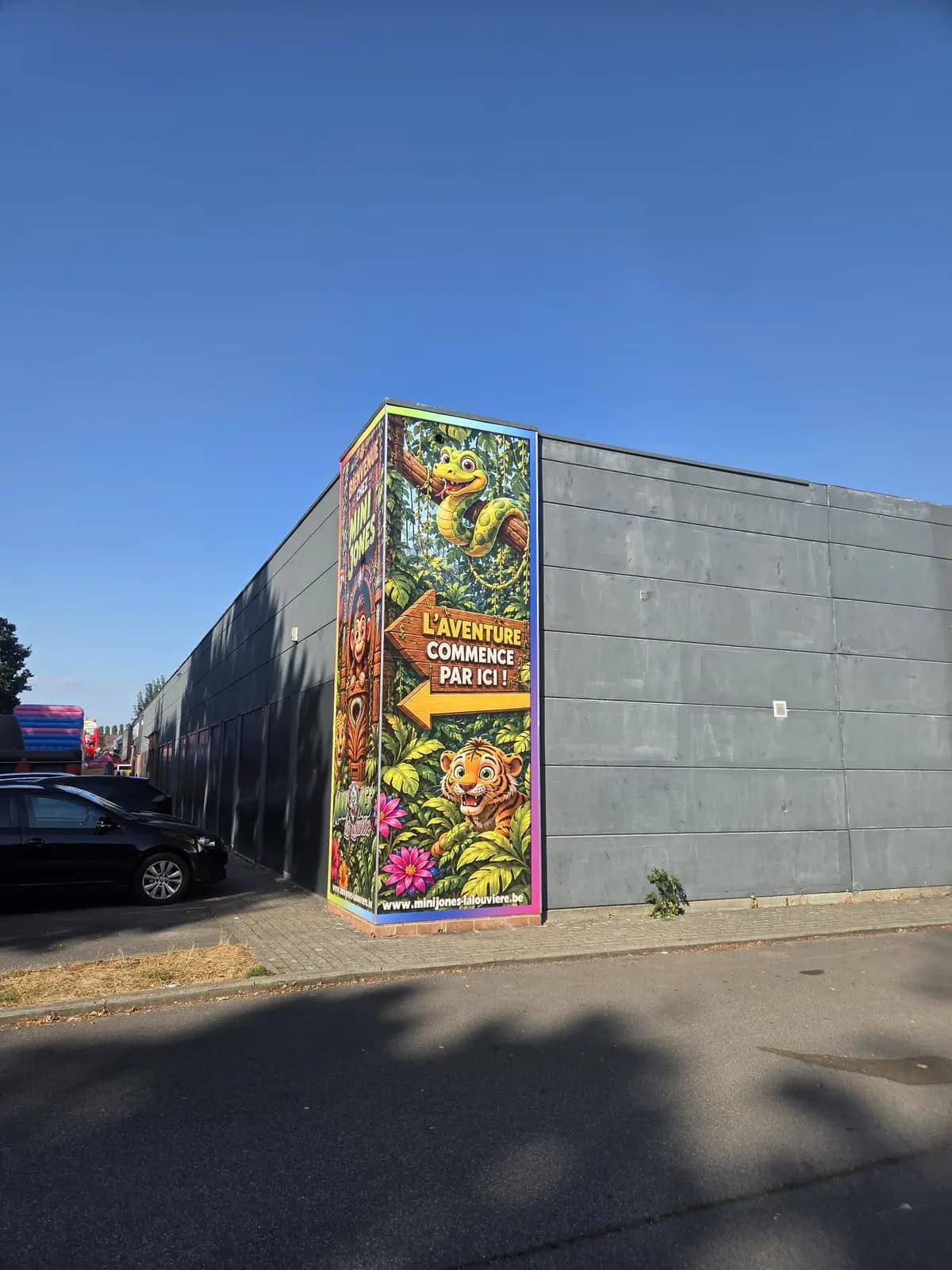 Habillage mural extérieur coloré thème jungle sur l'angle d'un bâtiment de parc de loisirs