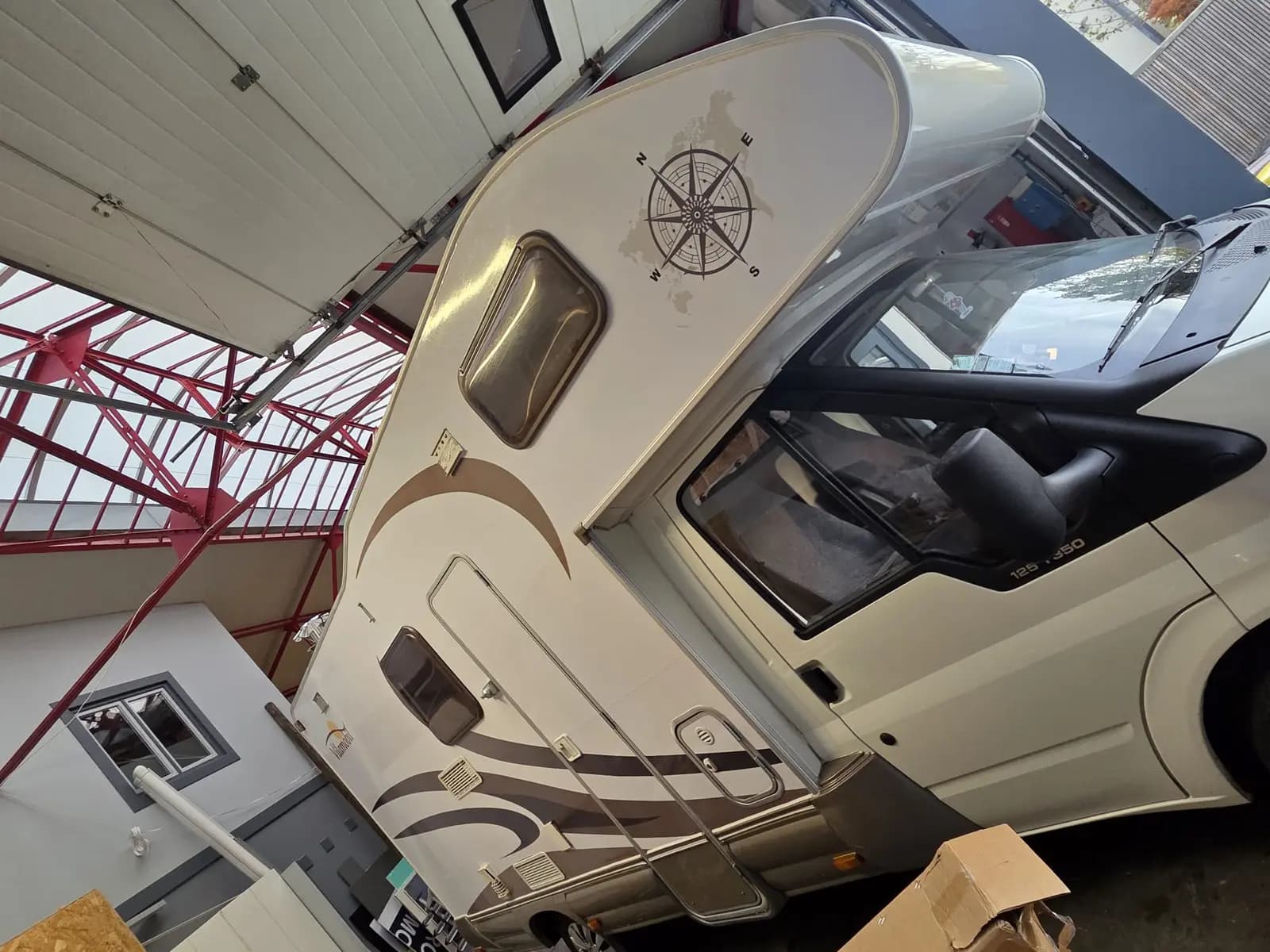 Camping-car avec décoration adhésive beige et marron et rose des vents sur la capucine