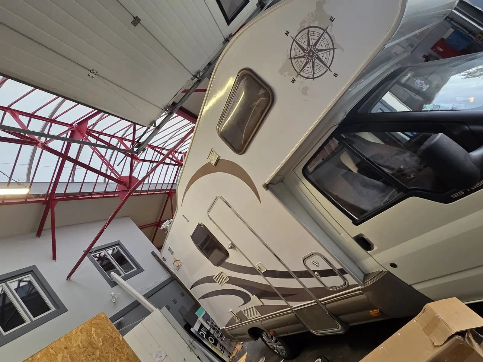 Capucine de camping-car décorée d'adhésifs marron avec boussole vue en atelier