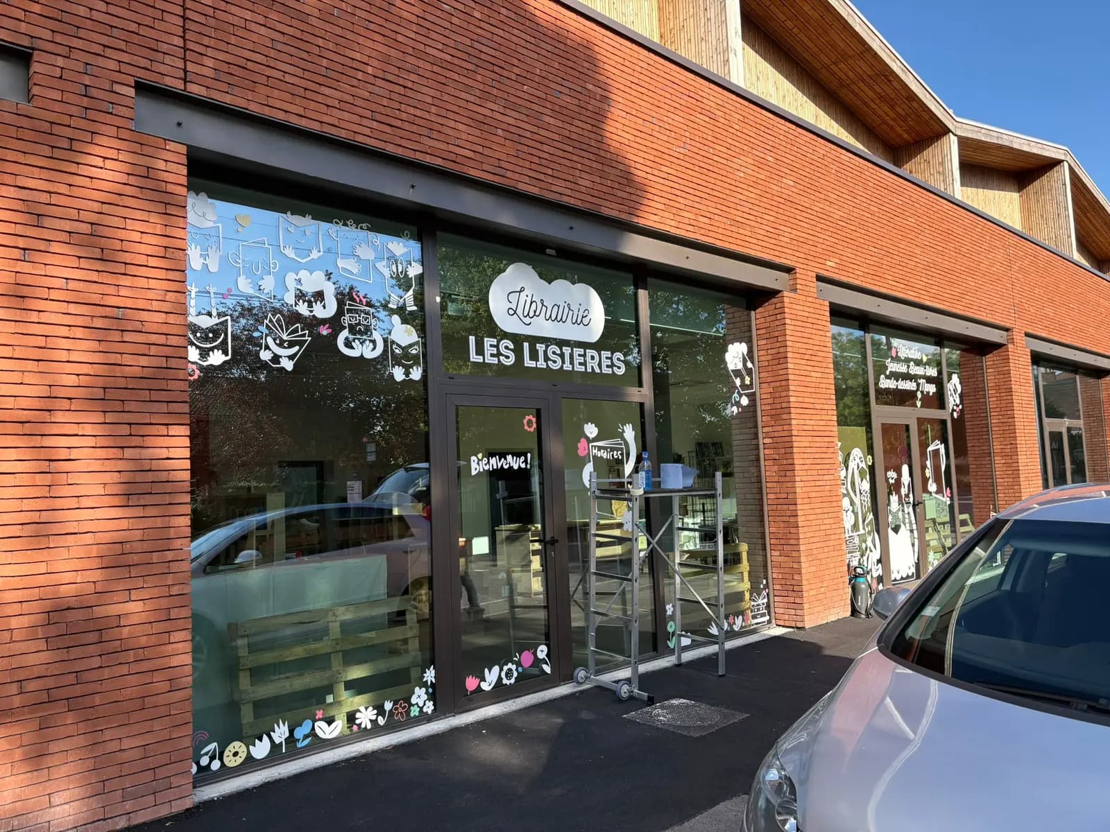 Façade complète de la librairie Les Lisières avec décor adhésif sur toutes les vitrines